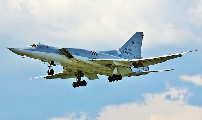 Russian military bomber aircraft in flight with landing gear down, linked to Putin may strike NATO warning context.