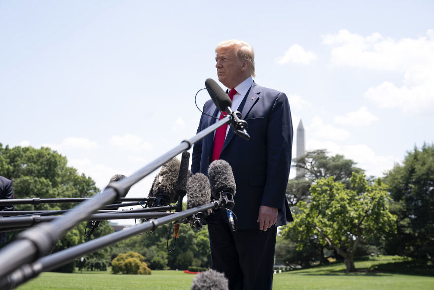 Donald Trump speaking to reporters outdoors, with microphones visible, discussing bizarre marks on his body.