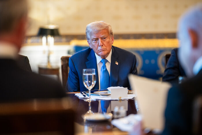 Donald Trump wearing a blue suit sitting at a table during a meeting about the HALT Fentanyl Act and overdose crisis.