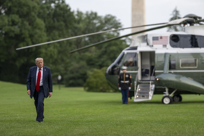 Former President Trump walking on grass near helicopter, illustrating why Trump won’t distance himself from Putin amid Ukraine arms shift.