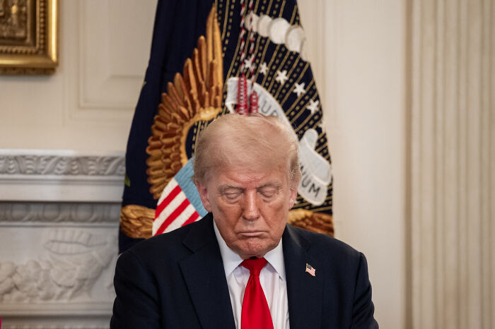 Former president sitting with head bowed in formal setting symbolizing 2024 presidential election impact on young Americans’ mental health