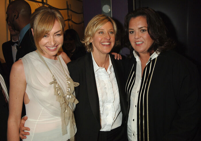 Ellen smiling and posing with Rosie O’Donnell and a friend at an indoor event, showing support amid Trump controversy.