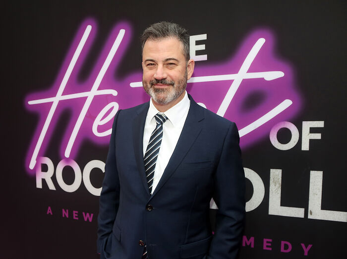 Man in a suit at a comedy event, representing late night TV amid discussions about Donald Trump targeting shows.