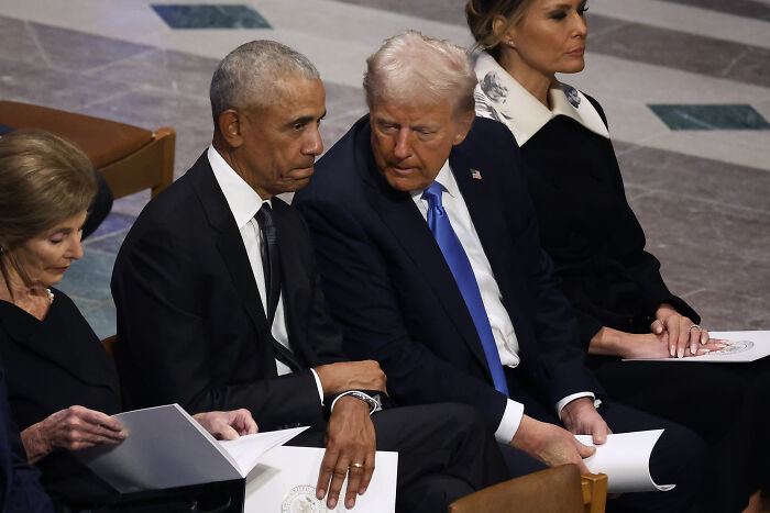 Barack Obama and Donald Trump seated and conversing during formal event, highlighting Trump treason allegations debate.
