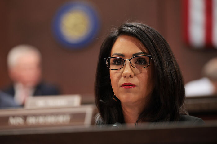 Congresswoman Lauren Boebert wearing glasses and dark hair, addressing issues related to her son’s child abuse citation.