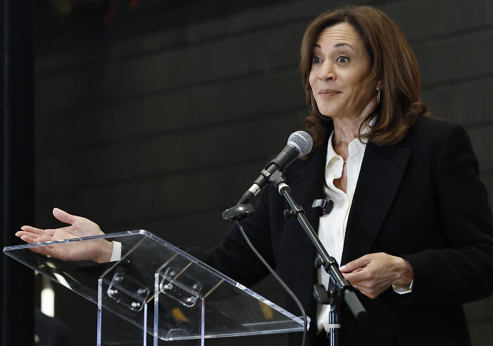 A woman speaking at a podium with a microphone, representing the impact of the 2024 presidential election on young Americans’ mental health.