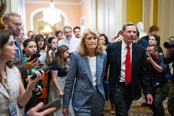 Senator Murkowski walking through a crowded hallway amid media coverage after casting a decisive swing-vote on GOP bill. Senator Murkowski walking through a crowded hallway amid media coverage after casting a decisive swing-vote on GOP bill.