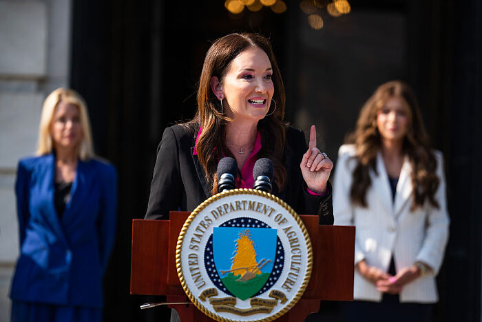 Agriculture Secretary speaking at podium, addressing Medicaid recipients and farmworker workforce replacement. Agriculture Secretary speaking at podium, addressing Medicaid recipients and farmworker workforce replacement.