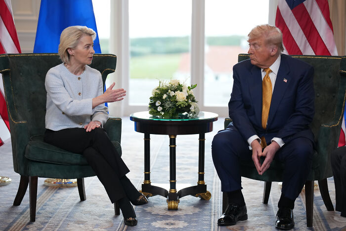 U.S. and EU leaders discussing trade deal with 15% tariffs on most European goods during a formal meeting.