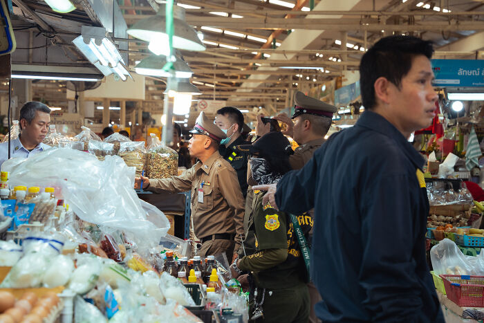 Police officers investigating at a Bangkok food market after a mass shooting with at least six people killed.