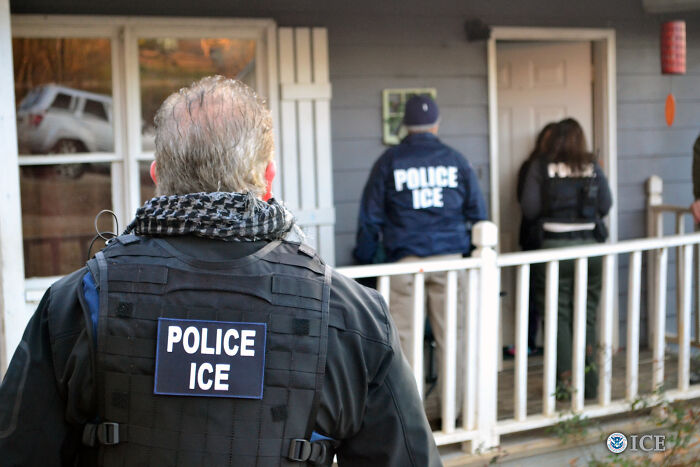 ICE officers in tactical gear outside a residential home raising concerns over access to Medicaid records and data use.