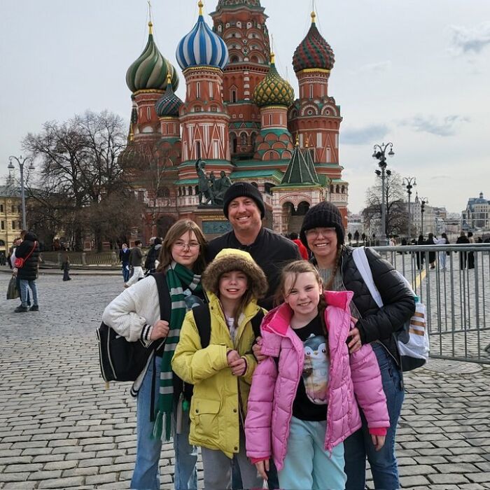 Family of five in winter coats posing in front of Saint Basil’s Cathedral, related to dad-of-three sent to front lines in Ukraine war.