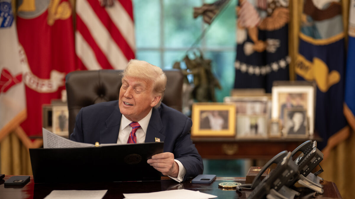 Donald Trump sitting at a desk in the Oval Office reading a document, related to AI deepfake and Obama arrest news.