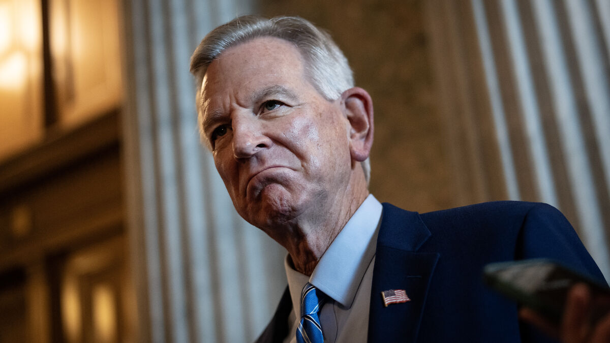 GOP senator speaking in a suit with an American flag pin, addressing claims about Trumpu2019s cankles and radical left-wingers.