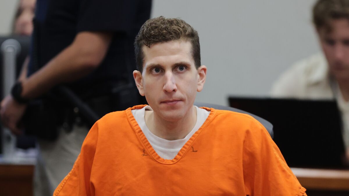 Bryan Kohberger in an orange prison jumpsuit sitting in a courtroom during a legal proceeding.
