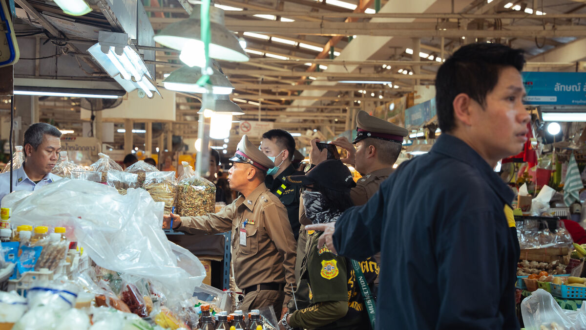 Police and investigators at a Bangkok food market after a mass shooting incident with multiple casualties.