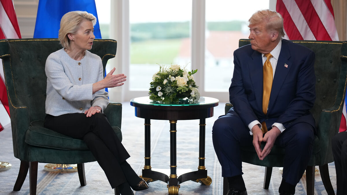 Two leaders in formal attire seated and discussing U.S. and EU trade deal with 15 percent tariffs on European goods.