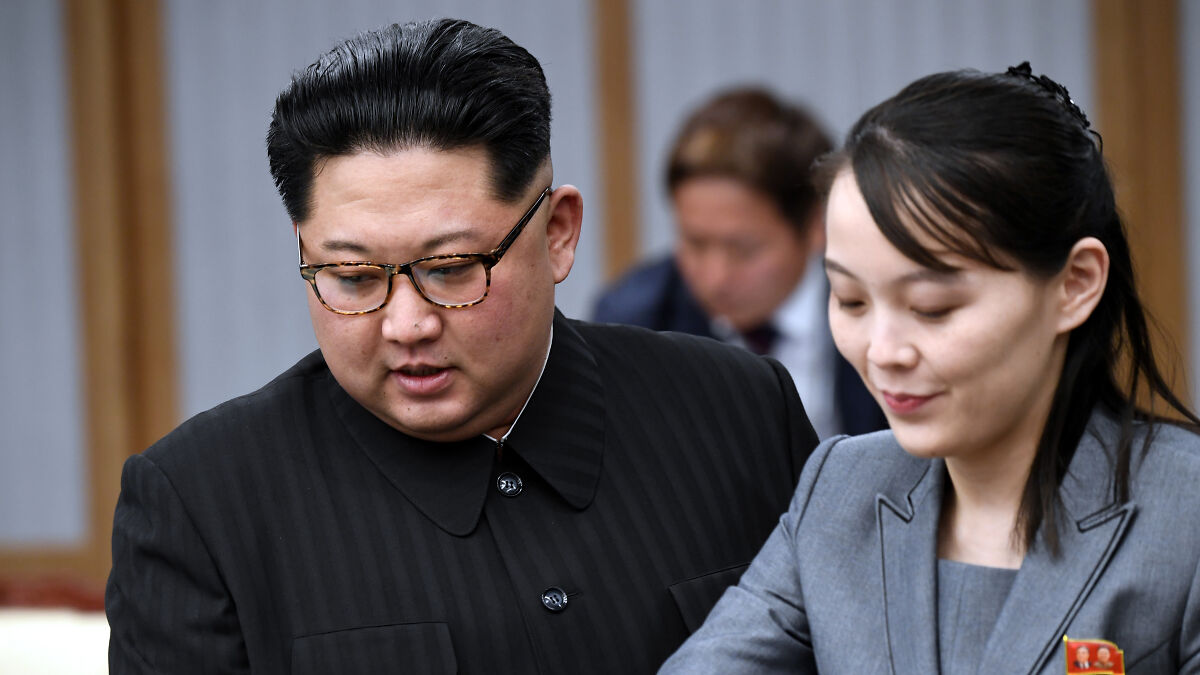 Kim Jong Unu2019s sister engaged in discussion, wearing a gray suit, highlighting rejection of South Korea dialogue efforts.