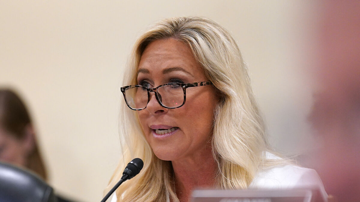 Marjorie Taylor Greene speaking at a hearing, wearing glasses and a white top, addressing the Gaza genocide situation.