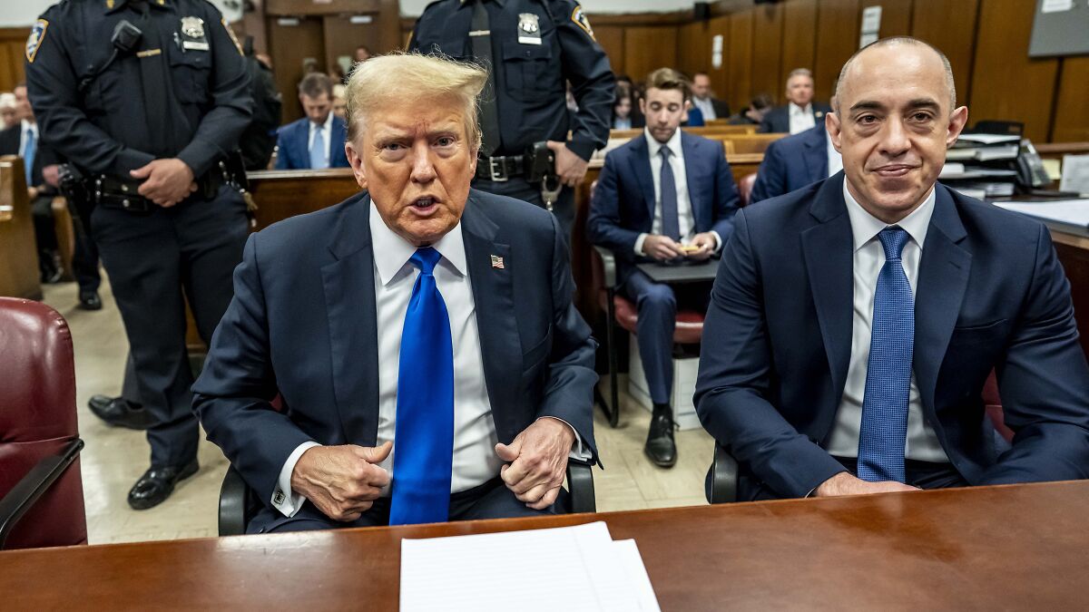 Former President Trump sitting beside Emil Bove in a courtroom during a hearing about lifetime judge confirmation.