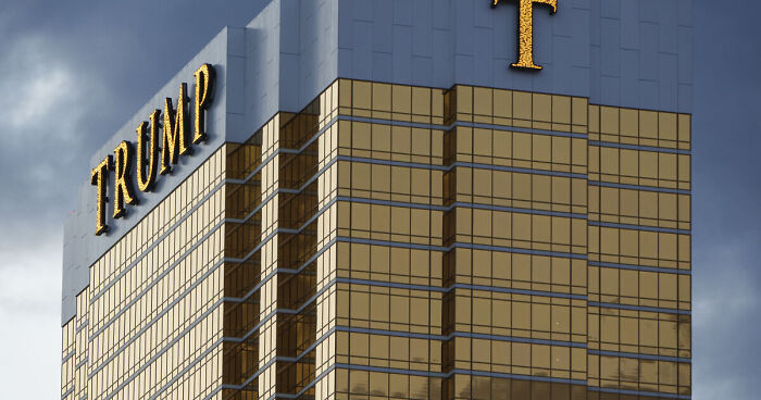 Trump Tower's golden glass facade against a cloudy sky, related to Trump tech trouble and AT&T glitch issues.