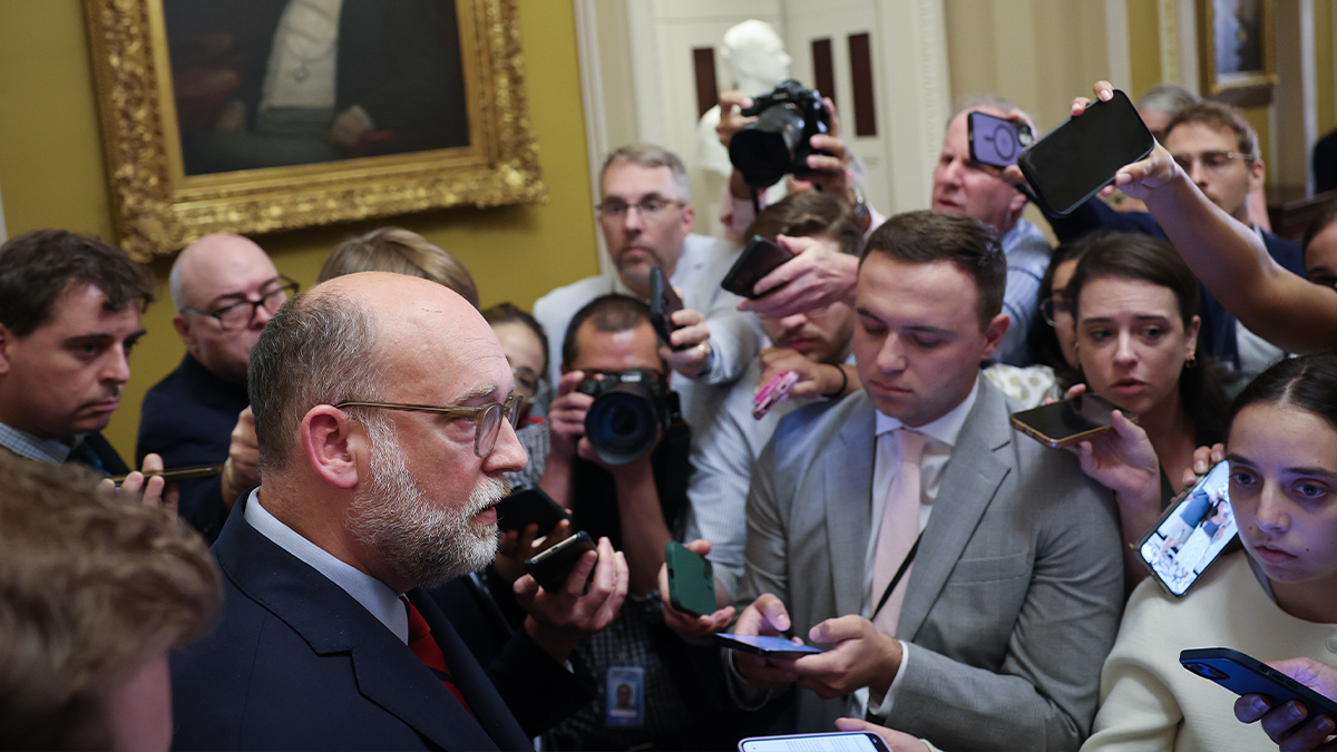 Senator speaking to reporters and photographers about Senate cuts package affecting foreign aid and public broadcasting funding.