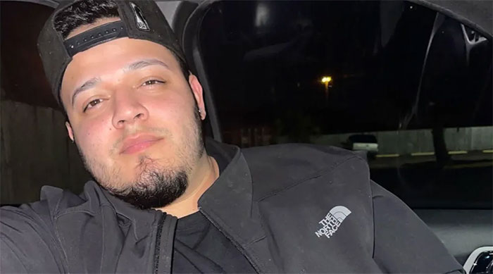 Kilmar Abrego Garcia wearing a black jacket and cap, sitting in a car at night after El Salvador jail ordeal.