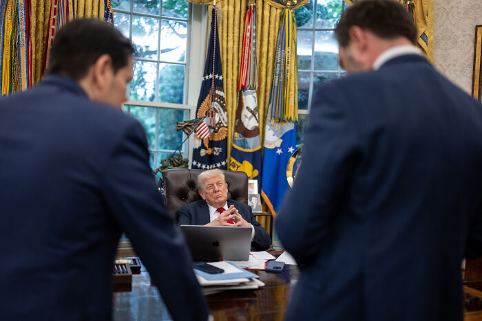 Donald Trump seated in the Oval Office during a meeting, symbolizing the Trump administration’s political actions.