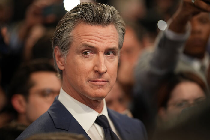 California Governor Gavin Newsom in a suit attending a public event, related to California redistricting plan discussions. California Governor Gavin Newsom in a suit attending a public event, related to California redistricting plan discussions.