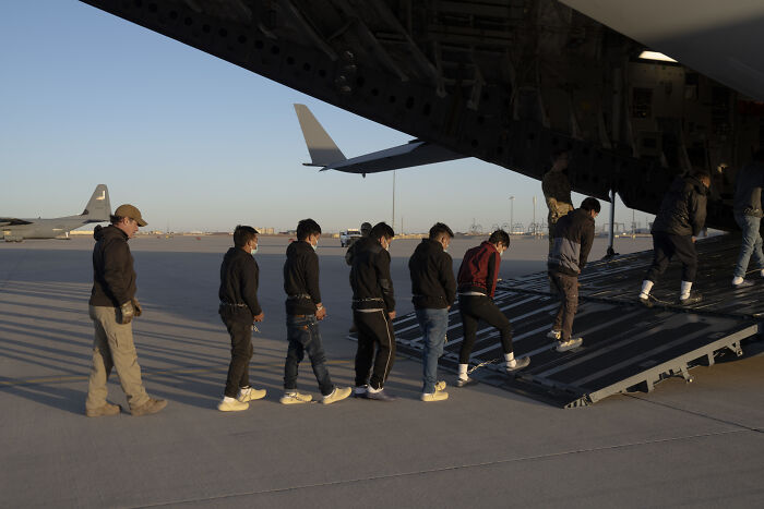 Foreign tourists boarding a plane under a new pilot program requiring up to $15,000 for U.S. visa payments.