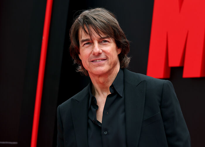 Man in a black suit at a red carpet event representing LGBTQ+ icon Gloria Gaynor as a MAGA donor after Trump honor.