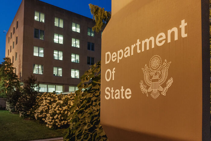 U.S. Department of State building at night, related to foreign tourists paying up to $15,000 for U.S. visa pilot program.