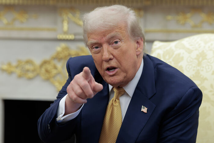 Former president in a suit pointing, related to senator and Epstein files investigation topics.