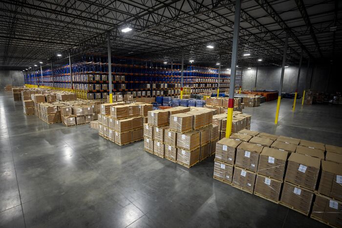 Warehouse storing large shipments of boxes symbolizing health cuts impacting women’s reproductive rights supply chains.
