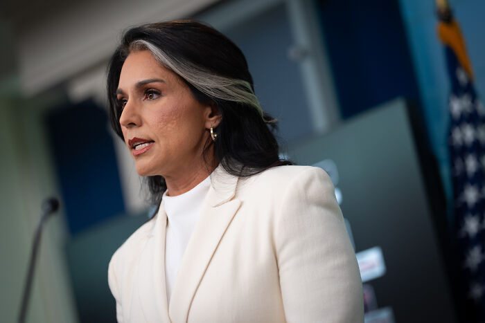 Tulsi Gabbard speaking at a press event, discussing revocation of clearances for alleged intelligence subversion.
