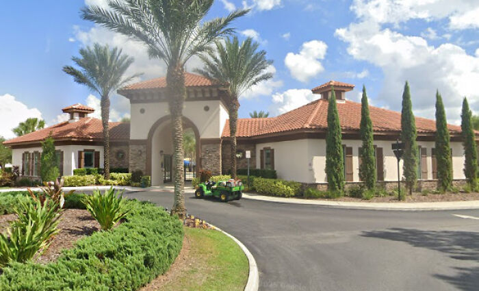 Modern residential community entrance with palm trees and clear sky, symbolizing the 9-year-old girl’s courageous move story.