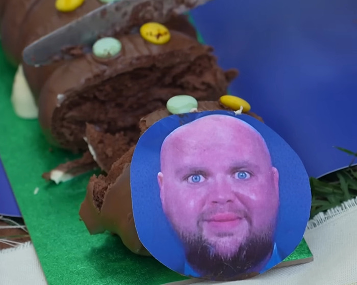 Chocolate cake designed as a convoy with a photo of D Vance, illustrating villagers’ fury over disabled parking incident.
