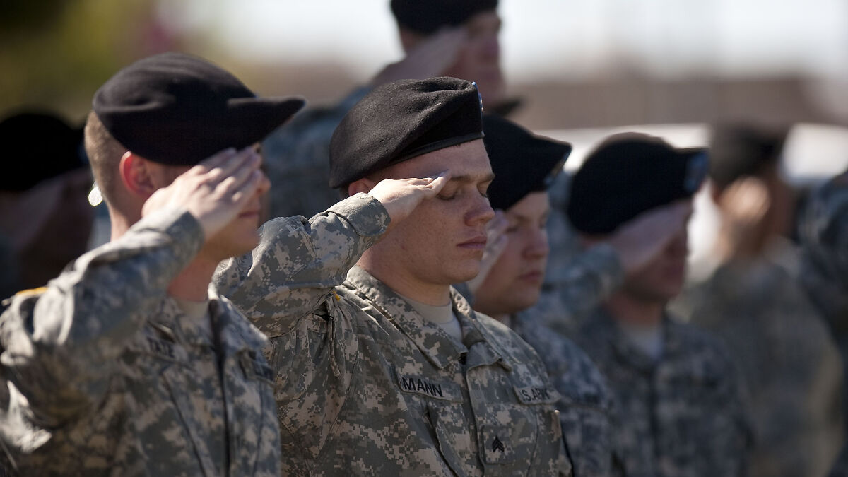 U.S. Air Force soldiers in uniform saluting during a formal military event, highlighting retirement pay policy changes.
