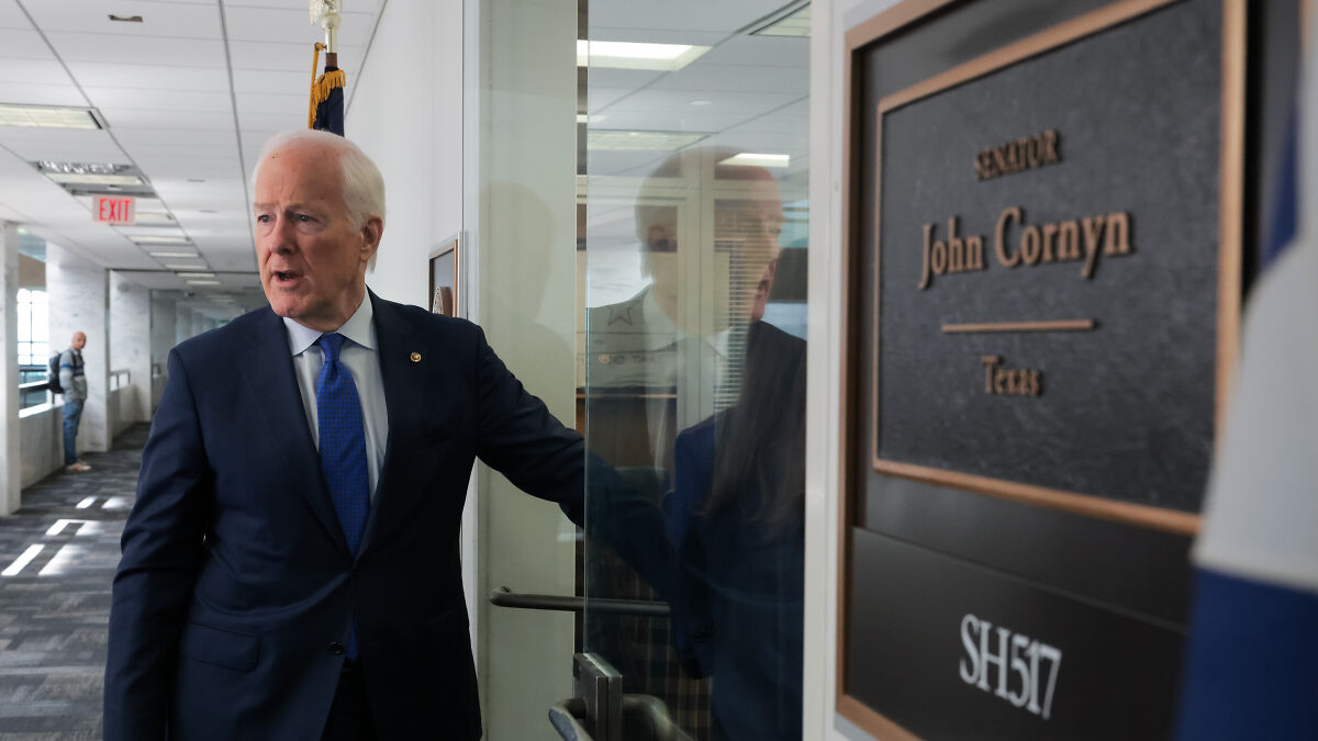 Senator John Cornyn near office door with nameplate, relating to FBIu2019s legal right and Texas lawmakers redistricting conflict.