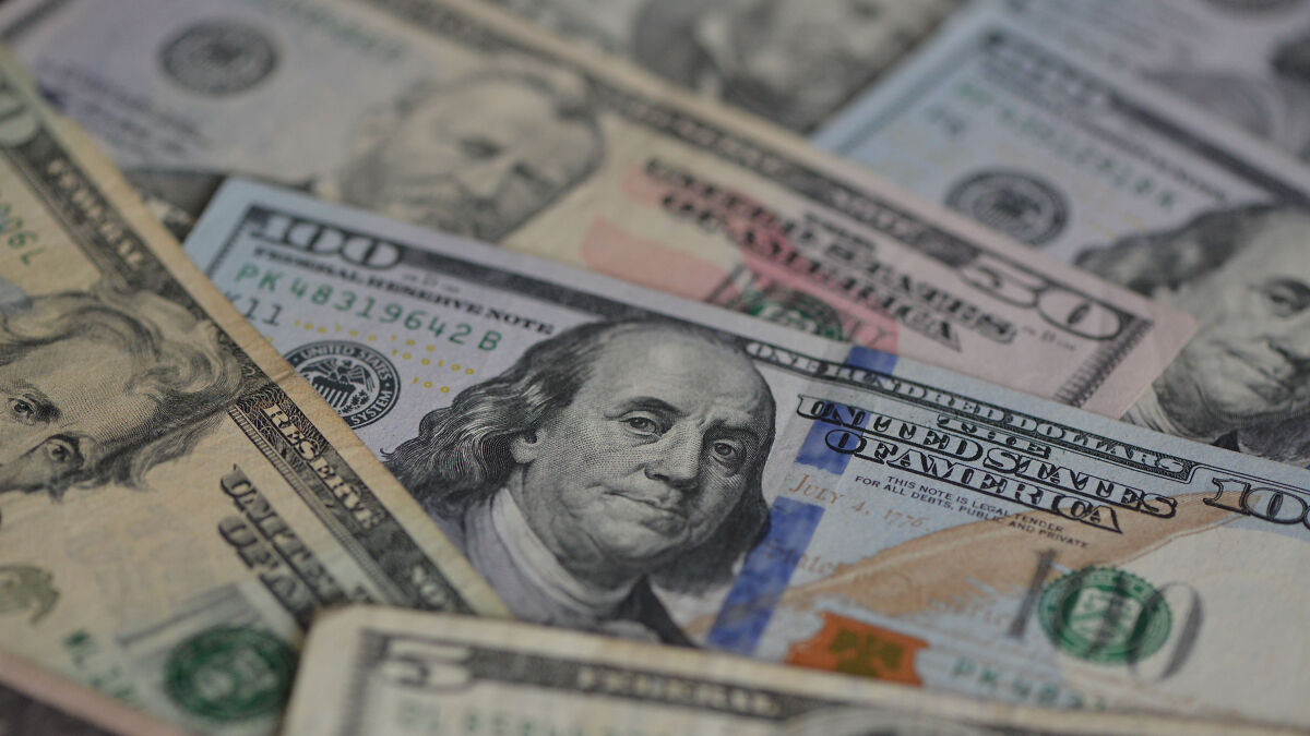 Close-up of U.S. currency bills representing the rising U.S. national debt and economic impact of tariffs.