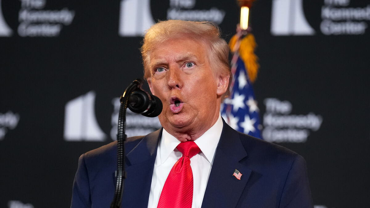 Donald Trump speaking at a podium during a public event with an American flag in the background and MSNBC host controversy.