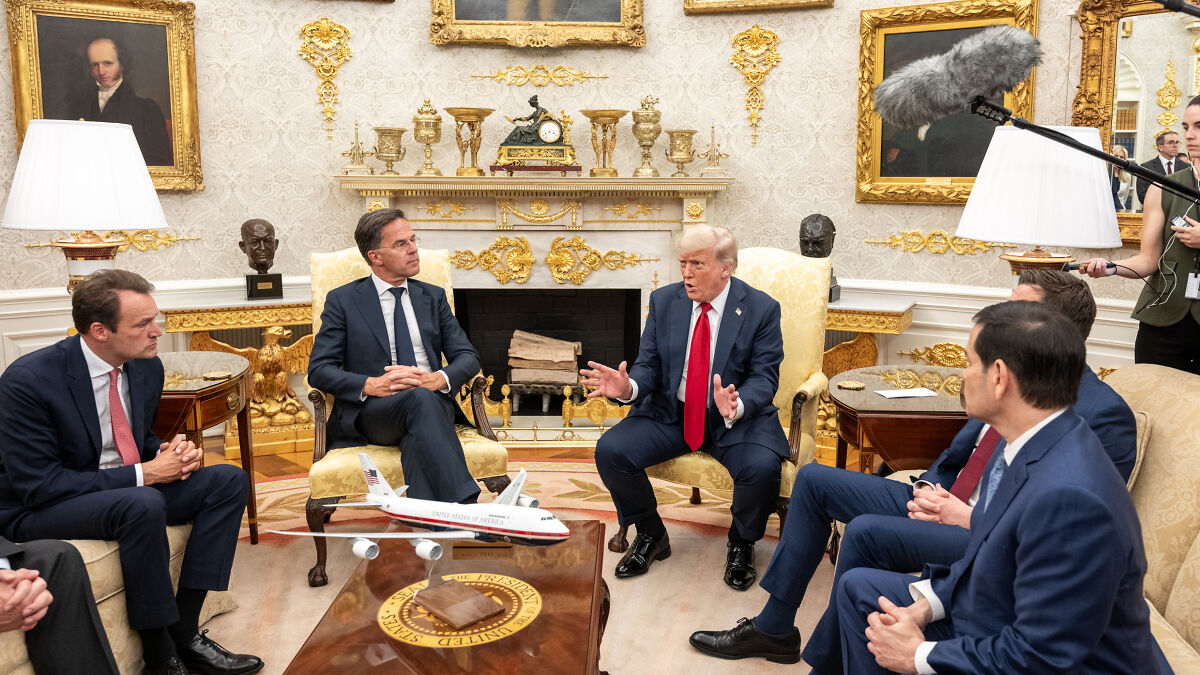 Donald Trump speaking during a meeting in the White House with golden decor and ornate furnishings resembling Home Depot style products.