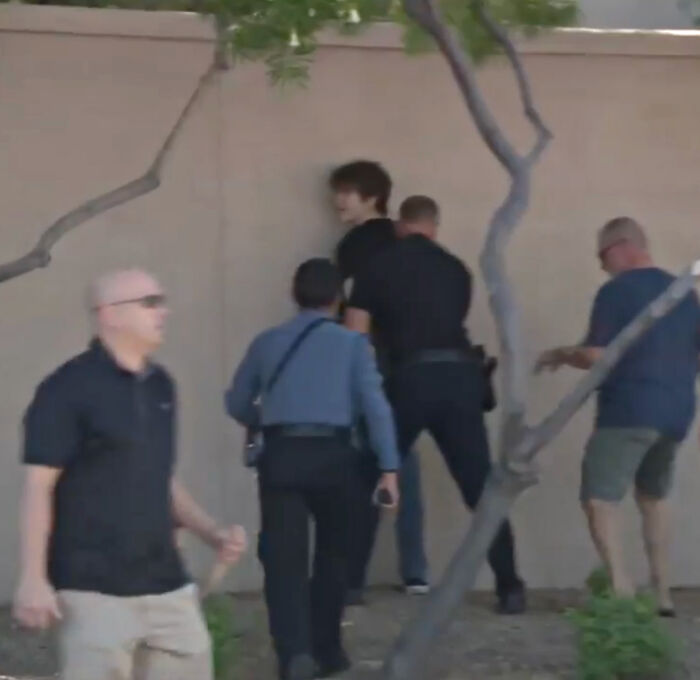 Teen wearing shirt like accused Charlie Kirk shooter being confronted by security at Turning Point USA memorial.