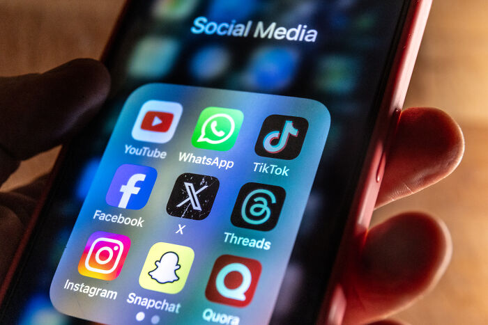 Close-up of a smartphone screen displaying popular social media apps related to social media influence and impact.