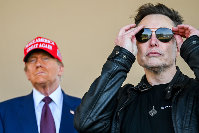 Donald Trump and Elon Musk pictured together, with Trump wearing a red hat and Musk adjusting sunglasses outdoors. Donald Trump and Elon Musk pictured together, with Trump wearing a red hat and Musk adjusting sunglasses outdoors.