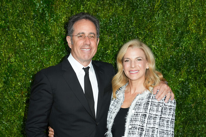 Jerry Seinfeld and wife Jessica at an event, with greenery background, relating to Free Palestine movement controversy. Jerry Seinfeld and wife Jessica at an event, with greenery background, relating to Free Palestine movement controversy.
