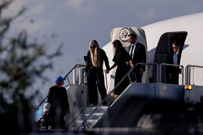 VP JD Vance boarding Air Force Two with others in a somber setting transporting Charlie Kirk’s casket home