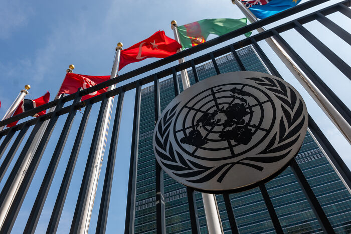United Nations building with flags and emblem, symbolizing the site of the UN speech mic incident involving Trump.