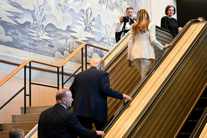 Former President Trump and Melania ascending escalator with security, linked to White House and UN staff sneaky plan claims.