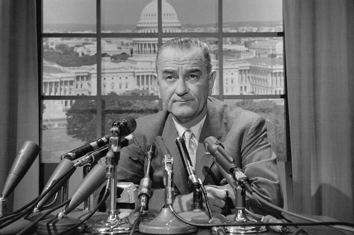 American president addressing the nation with multiple microphones in front, symbolizing presidents who waged war.